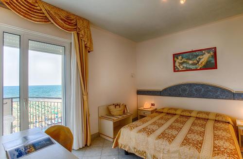 una camera con letto e vista sull'oceano di Hotel Elpiro a Lido di Jesolo