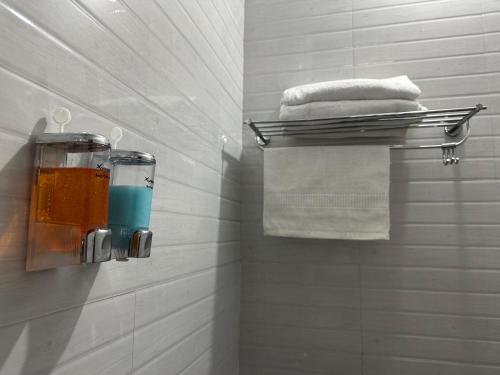 a bathroom with a towel rack and some towels at Woodside Haven in Auroville