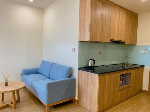 a living room with a blue couch and a table at PH Hotel & Apartment in Hai Phong