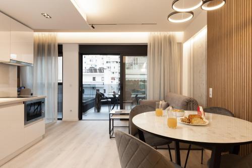 cocina y sala de estar con mesa y sillas en LUX&EASY Athens Metro Suites, en Atenas