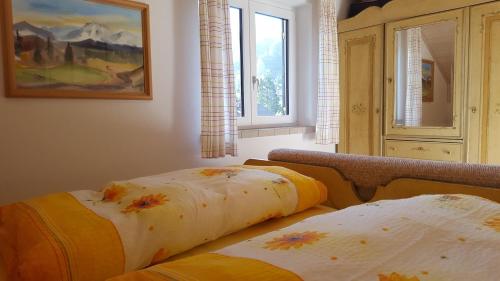 two beds sitting in a room with a window at Ferienwohnung Heimbeck Kochel in Kochel