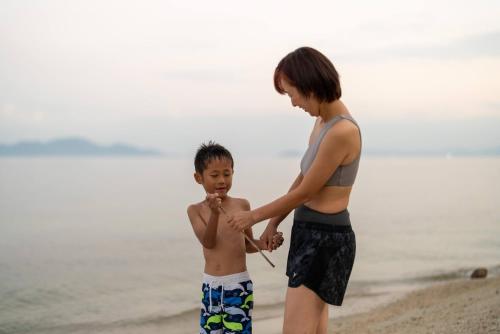 a woman and a young boy standing on the beach at IZA近江舞子 in Minami-komatsu