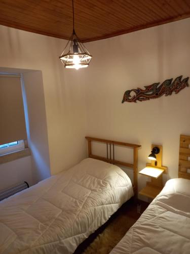 a bedroom with two twin beds and a lamp at Art`Rio - Casa no Rio em Dornes in Dornes