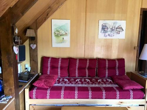 czerwona kanapa siedząca w pokoju w obiekcie Chalet de 2 chambres avec jardin amenage et wifi a Autrans Meaudre en Vercors w mieście Autrans