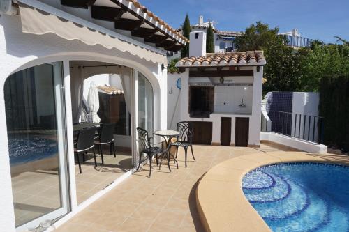 a patio with a pool and a table and chairs at Sol y Luna in Monte Pego