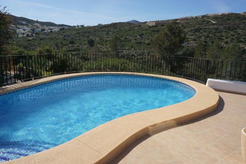 a swimming pool on a balcony with a mountain in the background at Sol y Luna in Monte Pego