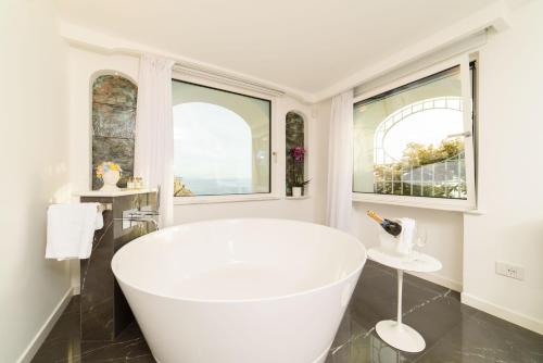 a white bath tub in a bathroom with windows at Palazzo Don Salvatore in Amalfi