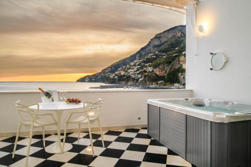 a bathroom with a bath tub and a table and chairs at Palazzo Don Salvatore in Amalfi