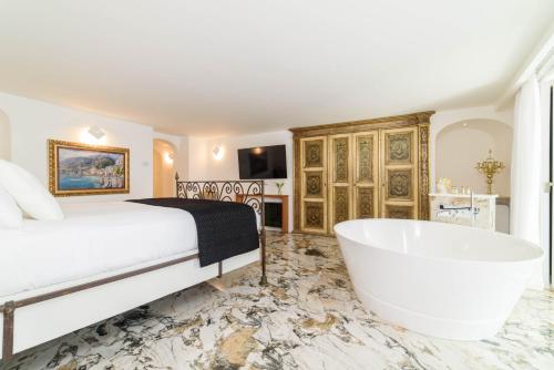 a bedroom with a large bed and a bathtub at Palazzo Don Salvatore in Amalfi