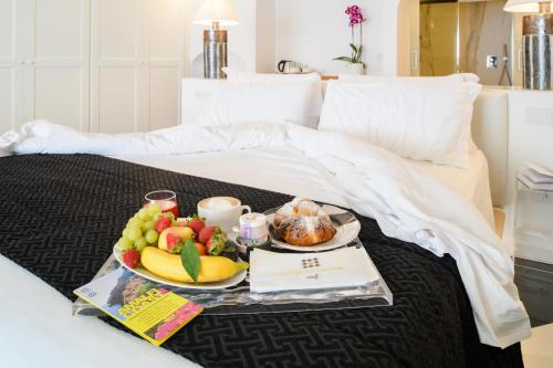 a tray of fruit and coffee on a bed at Palazzo Don Salvatore in Amalfi