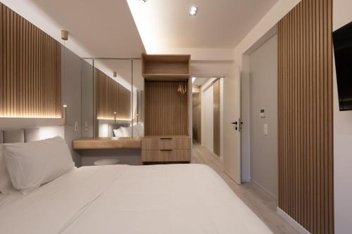 a bedroom with a large white bed and a sink at Incanto Boutique Suites - Neos Kosmos in Athens