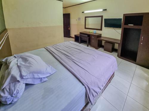 Ένα ή περισσότερα κρεβάτια σε δωμάτιο στο Hotel Halmahera Palangkaraya Mitra RedDoorz