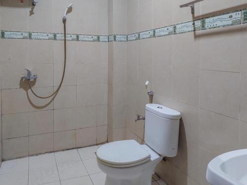 a bathroom with a toilet and a shower at Hotel Halmahera Palangkaraya Mitra RedDoorz in Palangkaraya