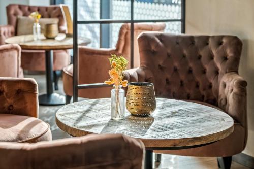 a table with a vase of flowers and chairs at Best Western Royal Holstebro in Holstebro