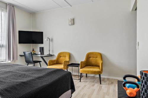 a bedroom with a bed and two chairs and a table at Best Western Royal Holstebro in Holstebro