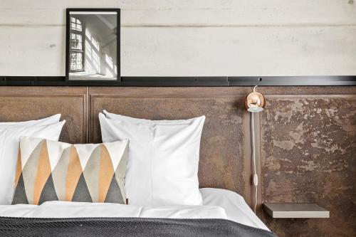 a bedroom with a bed with white pillows and a mirror at Best Western Royal Holstebro in Holstebro