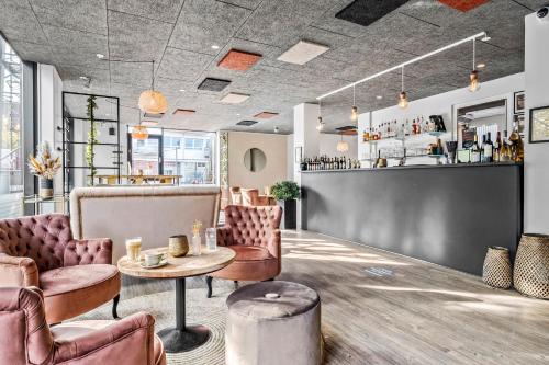 a bar with pink chairs and a table at Best Western Royal Holstebro in Holstebro