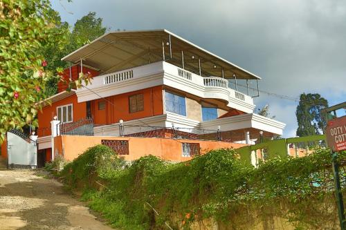 a large building with a balcony on top of it at New Ooty View Cottage in Ooty
