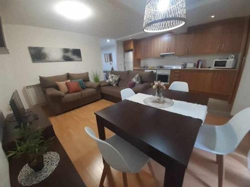 un soggiorno con tavolo nero e sedie bianche di Apartamento San Andrés a Teruel