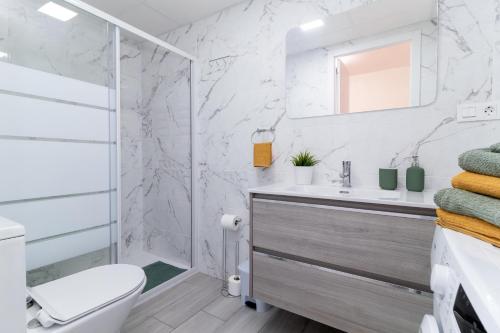 uma casa de banho branca com um lavatório e um chuveiro em Estrella del Mar em Torrevieja
