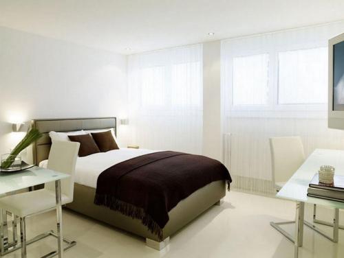 a bedroom with a bed and a table and a desk at VISIONAPARTMENTS Binzmühlestrasse 48 - contactless check-in in Zürich