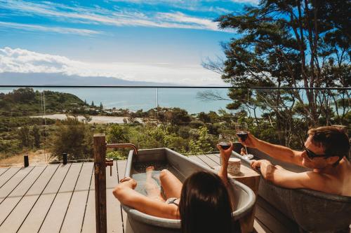 a man and a woman in a bath tub at Drift Off Grid Luxury Eco Glamping in Tarakohe