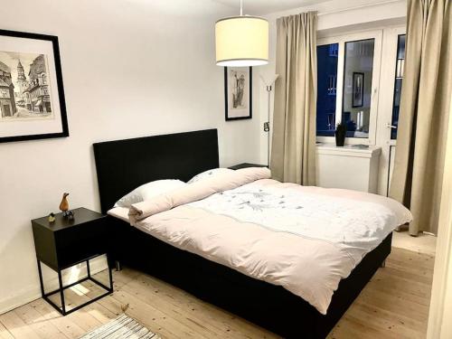 a bedroom with a large bed with a black headboard at Martha in Aalborg