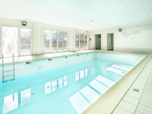 une grande piscine avec de l'eau bleue dans l'établissement Vacancéole - Le Hameau de l'Alpage, à Saint-Sorlin-dʼArves