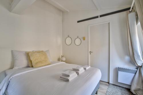 une chambre avec un lit blanc avec des serviettes dessus dans l'établissement 42.Studio 4Pers#Madeleine#Gallerie La Fayette, à Paris