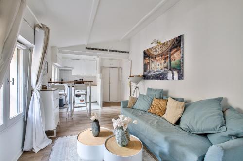 un salon avec un canapé bleu et une cuisine dans l'établissement 42.Studio 4Pers#Madeleine#Gallerie La Fayette, à Paris