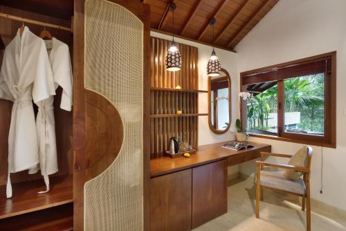 a bathroom with a wooden desk and a mirror at Jannata Resort and Spa in Ubud