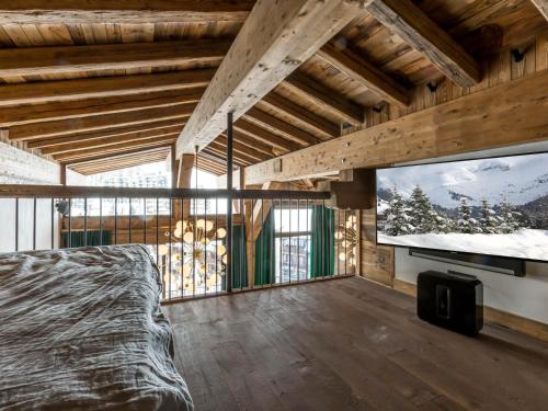 - une chambre avec une télévision à grand écran et un lit dans l'établissement Duplex 5 pièces luxe aux pieds des pistes avec hammam et cheminée - FR-1-694-87, à Val dʼIsère