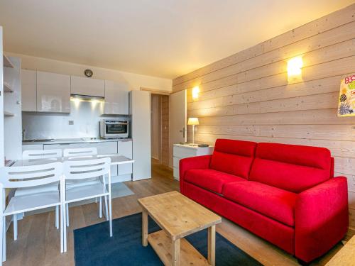 un salon avec un canapé rouge et une table dans l'établissement Studio charmant skis aux pieds, balcon, coeur de Val-d'Isère, 4 pers, WiFi - FR-1-694-231, à Val dʼIsère