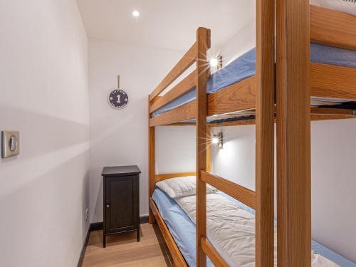 Cette chambre dispose de lits superposés avec 2 lits superposés et une table. dans l'établissement Appartement élégant à Val-d'Isère avec balcon, parking, wifi - FR-1-694-270, à Val dʼIsère