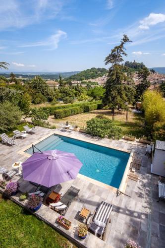 - une vue sur la piscine avec un parasol et des chaises dans l'établissement Cottage provencal - Villa saint Marc, à Forcalquier