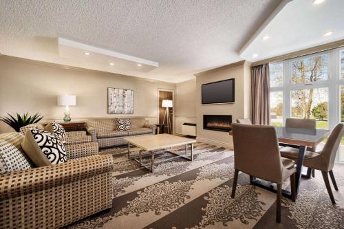 a living room with a couch and a table at Ramada by Wyndham Cornwall in Cornwall