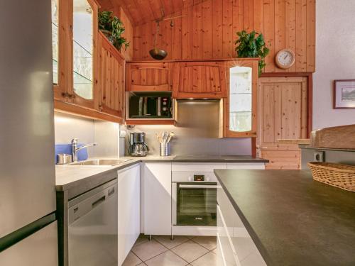 une cuisine avec des armoires en bois et un comptoir dans l'établissement Spacieux appartement 9 pers. à Val-d'Isère, skis aux pieds, Wi-Fi, proche commodités - FR-1-694-306, à Val dʼIsère