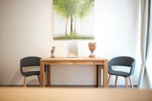 a table with two chairs and a laptop on it at Apartments zur alten Konditorei in Schwerin