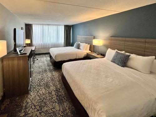 a hotel room with two beds and a flat screen tv at Clarion Hotel & Convention Center Joliet in Joliet