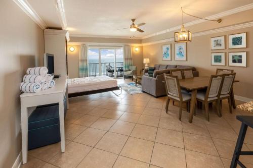 ein Wohnzimmer mit einem Tisch und einem Esszimmer in der Unterkunft Escapes! To The Shores Orange Beach, A Ramada by Wyndham in Orange Beach