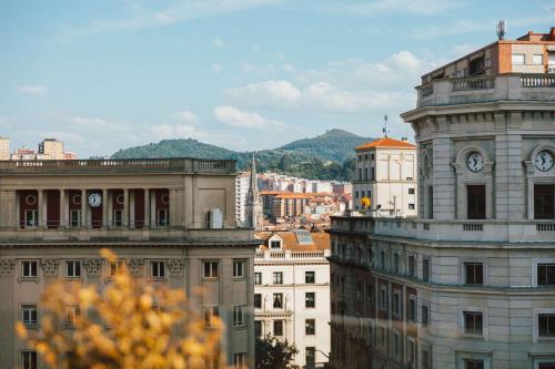 un gruppo di edifici con torre dell'orologio di Radisson Collection Bilbao a Bilbao