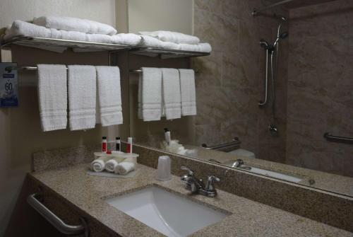 a bathroom with a sink and a mirror and towels at Travelodge by Wyndham Trinidad in Trinidad