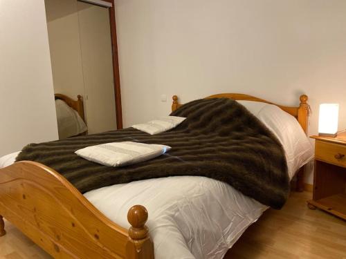 uma cama com um cobertor preto em cima em Bel Appartement modernisé avec terrasse. em Villar-Saint-Pancrace