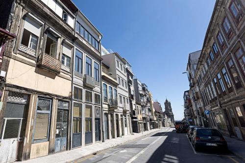 een lege straat met gebouwen en een auto bij Urban House by LovelyStay in Porto