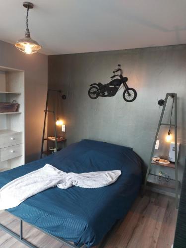 a bedroom with a bed with a motorcycle hanging on the wall at Style of Industry in Morbier