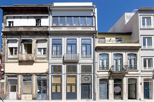 een hoog wit gebouw met veel ramen aan een straat bij Urban House by LovelyStay in Porto