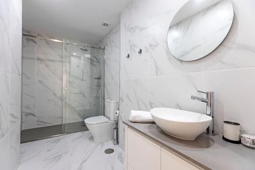 a bathroom with a sink and a toilet and a mirror at Urban House by LovelyStay in Porto
