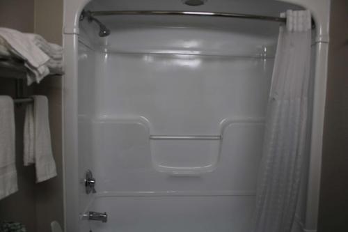 a white shower with a shower curtain in a bathroom at Days Inn by Wyndham Waco University Area in Waco