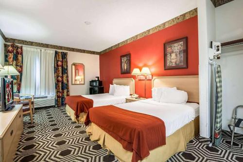 duas camas num quarto de hotel com paredes vermelhas em Days Inn by Wyndham Kentland em Kentland