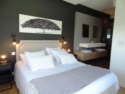 a bedroom with a large white bed and a sink at Luxueuse propriété SAINT CIRICE aux vues aériennes in Cahors